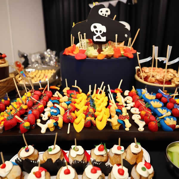 Un buffet de pirate familial surmonté d'un chapeau de pirate noir et blanc avec une tête de mort imprimée.